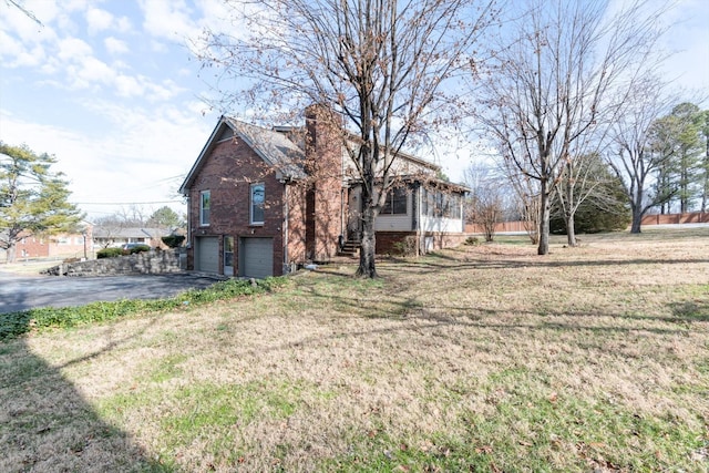 exterior space with a garage and a lawn