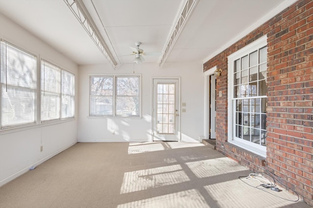 unfurnished sunroom with ceiling fan