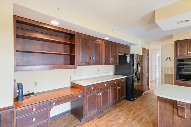 kitchen featuring light hardwood / wood-style floors, black appliances, dark brown cabinets, and built in desk