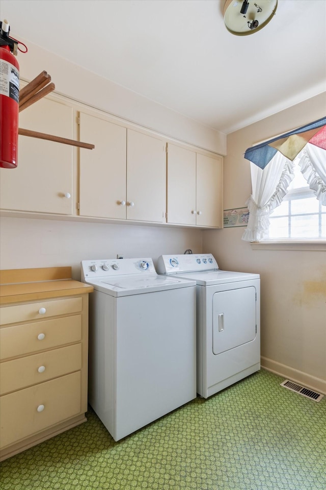 laundry area with cabinets and separate washer and dryer