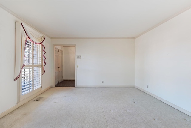 empty room featuring light colored carpet and ornamental molding