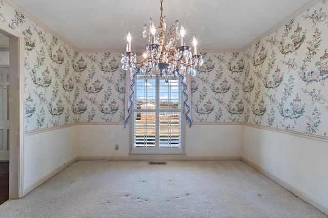 unfurnished dining area featuring light colored carpet, crown molding, and a notable chandelier