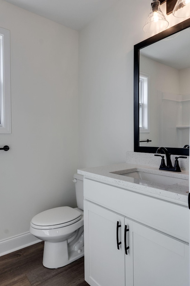 bathroom with toilet, vanity, and hardwood / wood-style flooring