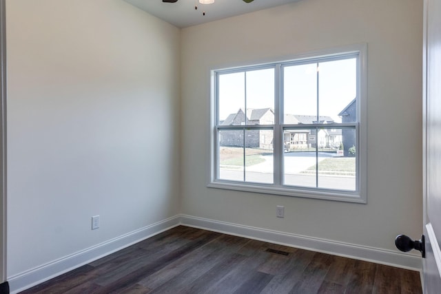 spare room featuring ceiling fan and dark wood-type flooring