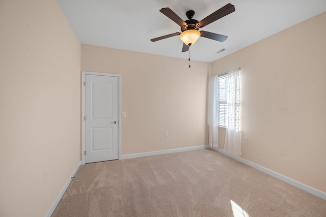 spare room featuring light carpet and ceiling fan