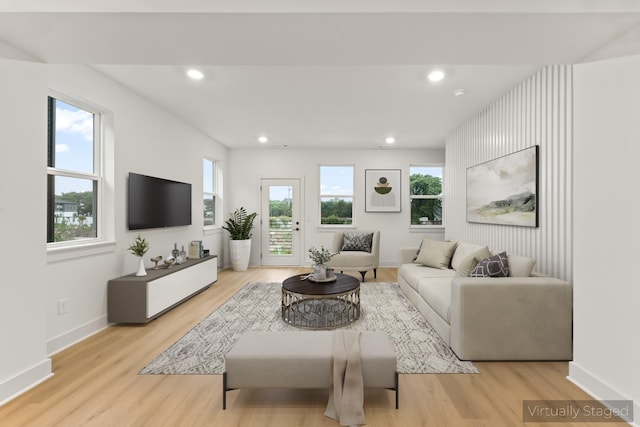 living room with a wealth of natural light and light hardwood / wood-style flooring