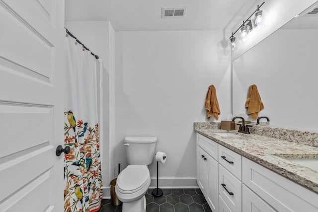 bathroom featuring tile patterned floors, vanity, and toilet