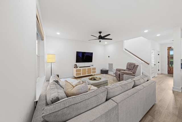 living room featuring light wood-type flooring and ceiling fan