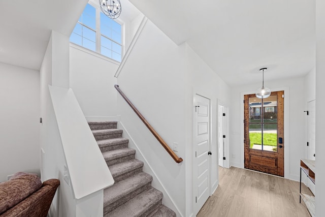 foyer entrance with a notable chandelier and light hardwood / wood-style flooring