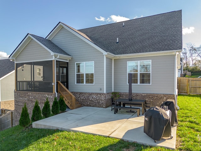 back of house with a yard, a sunroom, and a patio