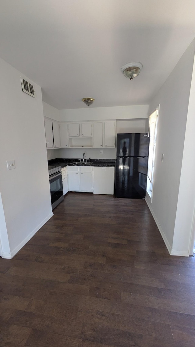 kitchen featuring white cabinets, sink, dark hardwood / wood-style floors, black fridge, and stainless steel electric range