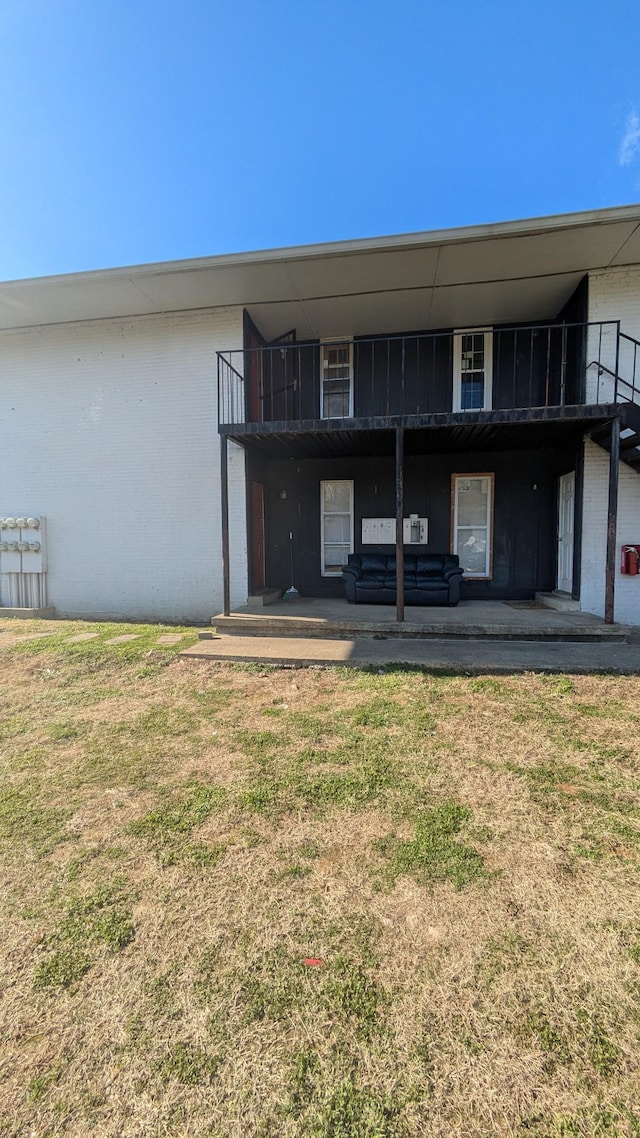 back of house featuring a patio area and a yard