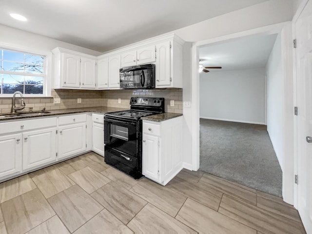 kitchen featuring black appliances, light carpet, sink, and white cabinetry