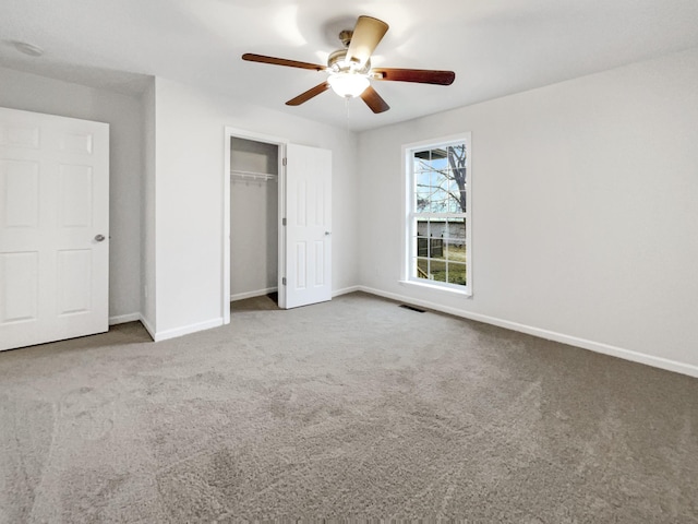 unfurnished bedroom featuring ceiling fan, a closet, and carpet