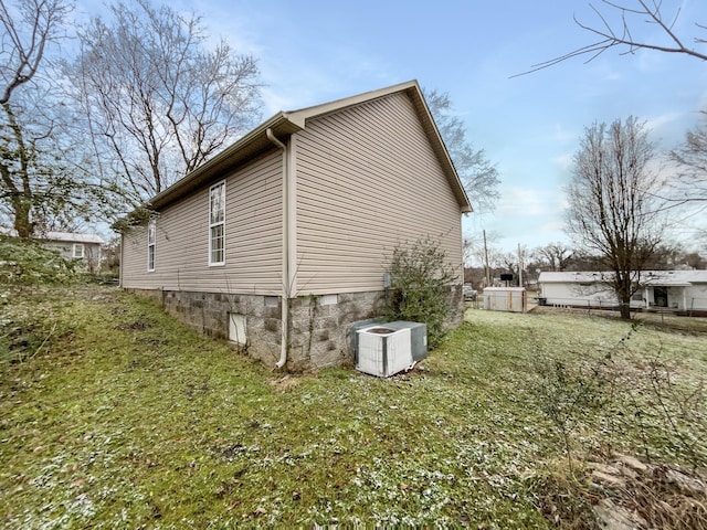 view of property exterior with a yard and central AC