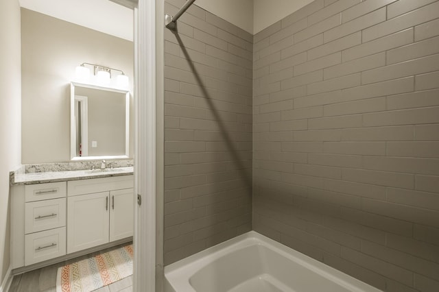 bathroom featuring vanity and tiled shower / bath