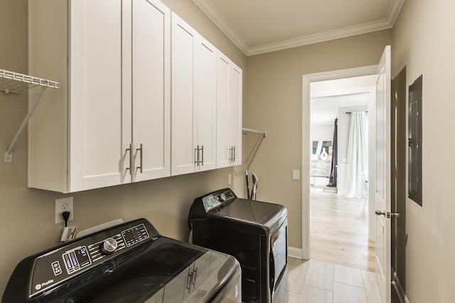 laundry area with washing machine and dryer, ornamental molding, and cabinets