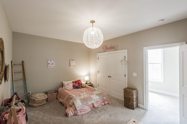 bedroom with light carpet and a notable chandelier