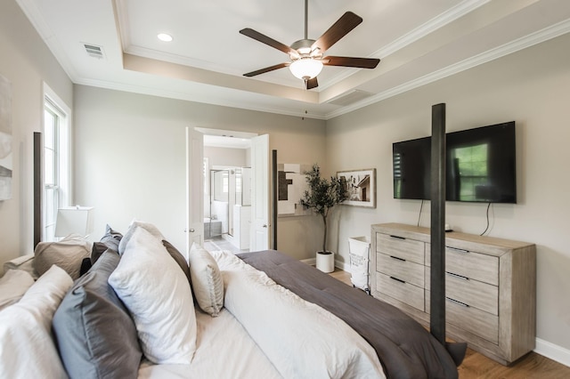 bedroom with light wood-type flooring, ceiling fan, crown molding, and a tray ceiling