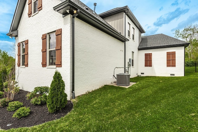 view of property exterior with central air condition unit and a yard