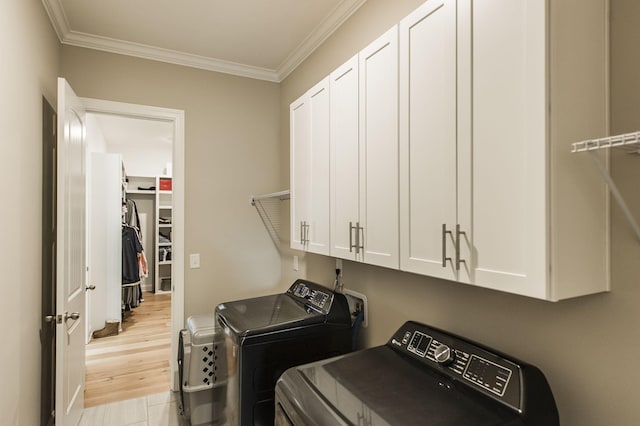 clothes washing area with light hardwood / wood-style flooring, independent washer and dryer, crown molding, and cabinets