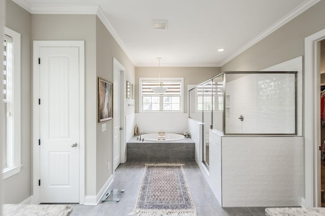 bathroom with ornamental molding and shower with separate bathtub