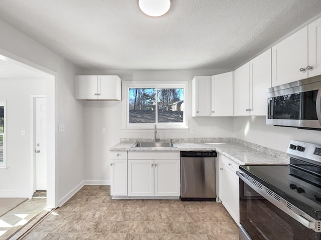 kitchen with stainless steel appliances, white cabinets, and sink