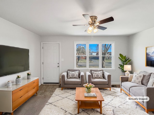 living room with ceiling fan and dark colored carpet