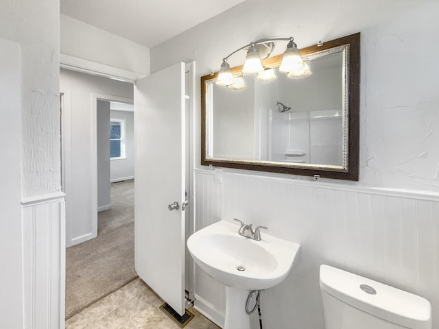 bathroom with toilet, a shower, and sink