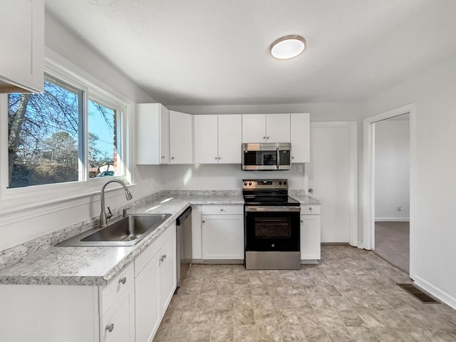 kitchen with white cabinets, appliances with stainless steel finishes, and sink