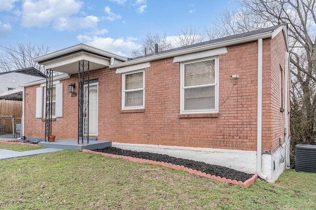 view of front of property with central air condition unit and a front lawn