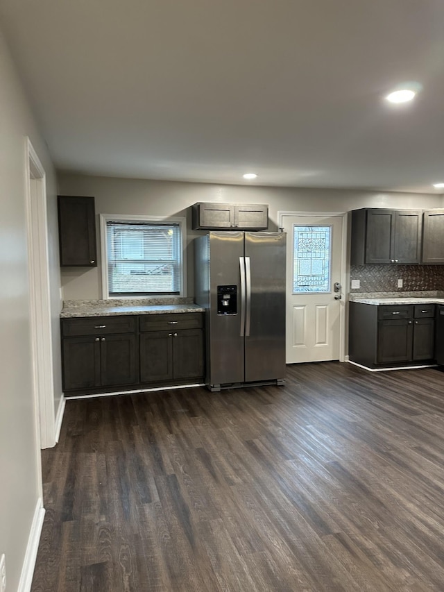 kitchen featuring stainless steel refrigerator with ice dispenser, dark wood-type flooring, decorative backsplash, and a healthy amount of sunlight