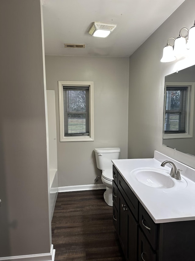 bathroom featuring toilet, wood-type flooring, and vanity