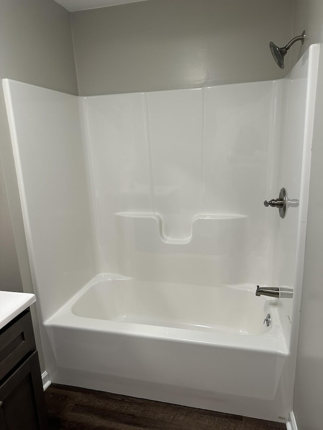 bathroom with shower / bath combination, hardwood / wood-style floors, and vanity