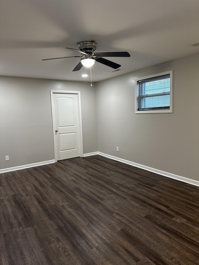 empty room featuring ceiling fan and dark wood-type flooring