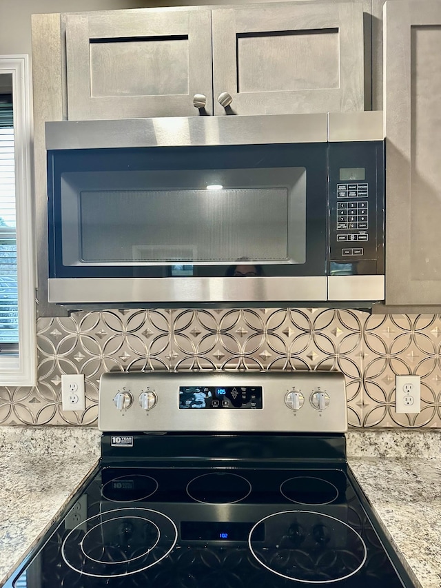 room details featuring light stone countertops, appliances with stainless steel finishes, and tasteful backsplash