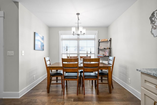 dining area featuring dark wood-type flooring and a notable chandelier