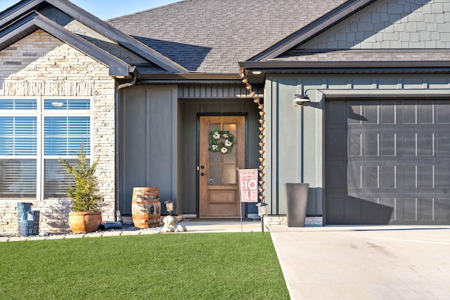 view of exterior entry with a garage and a yard