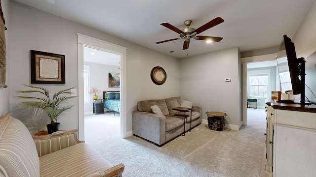 carpeted living room with ceiling fan