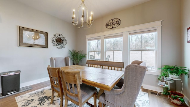 dining room with a wealth of natural light, a notable chandelier, and light wood-type flooring