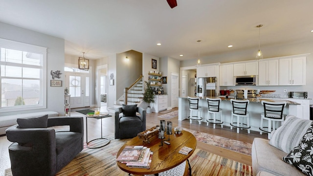 living room with sink, hardwood / wood-style floors, and a notable chandelier