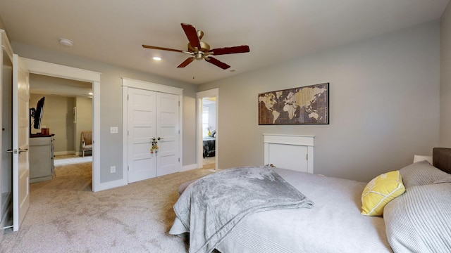 carpeted bedroom with ceiling fan and a closet