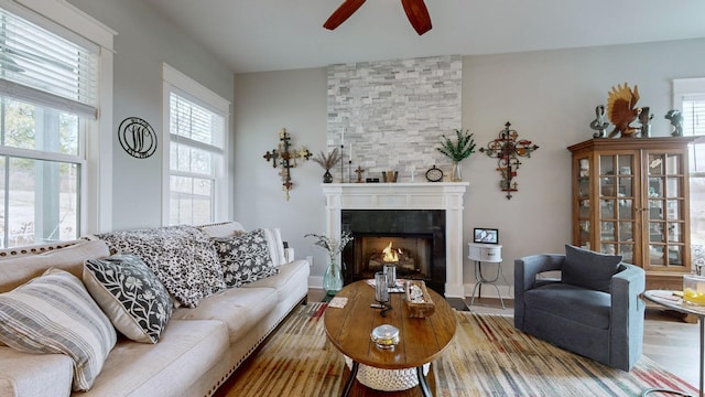 living room featuring ceiling fan, a fireplace, and hardwood / wood-style floors