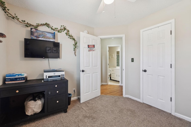 carpeted bedroom featuring a textured ceiling and ceiling fan