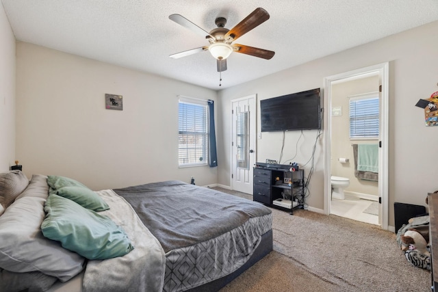 carpeted bedroom featuring a textured ceiling, ceiling fan, ensuite bathroom, and a closet