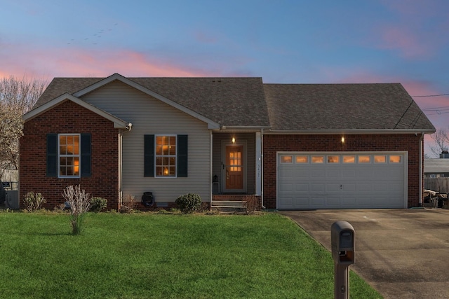 ranch-style house featuring a garage and a lawn