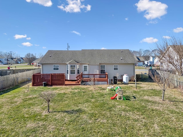 back of property with a deck and a yard