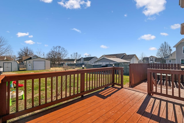 wooden terrace featuring a storage unit and a yard