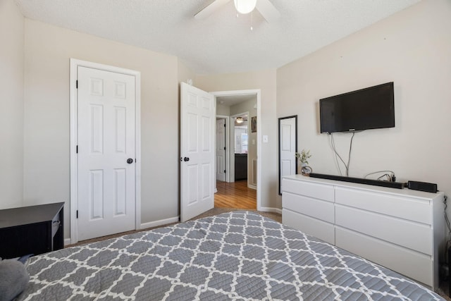 bedroom with ceiling fan and a textured ceiling