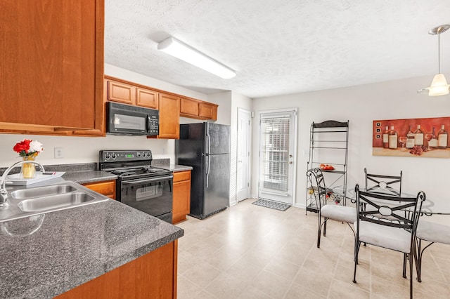 kitchen featuring sink, pendant lighting, black appliances, and a textured ceiling